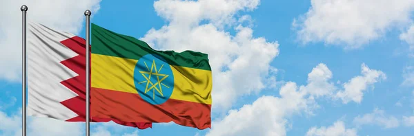 一緒に白い曇り青い空に対して風に手を振るバーレーンとエチオピアの旗。外交概念、国際関係. — ストック写真