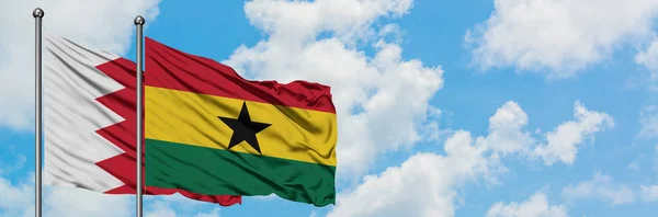 Bandera de Bahréin y Ghana ondeando en el viento contra el cielo azul nublado blanco juntos. Concepto diplomático, relaciones internacionales . — Foto de Stock