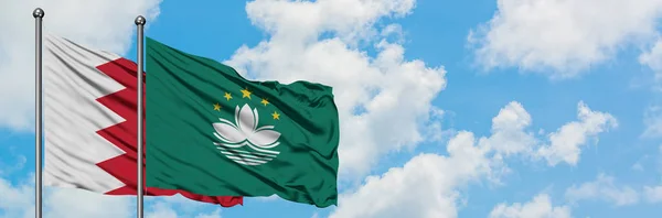 Bandera de Bahréin y Macao ondeando en el viento contra el cielo azul nublado blanco juntos. Concepto diplomático, relaciones internacionales . — Foto de Stock