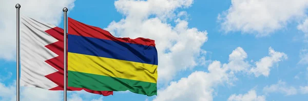 Bahrain and Mauritius flag waving in the wind against white cloudy blue sky together. Diplomacy concept, international relations. — Stock Photo, Image