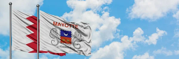 Bandera de Bahréin y Mayotte ondeando en el viento contra el cielo azul nublado blanco juntos. Concepto diplomático, relaciones internacionales . —  Fotos de Stock