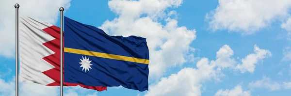 Bandera de Bahréin y Nauru ondeando en el viento contra el cielo azul nublado blanco juntos. Concepto diplomático, relaciones internacionales . — Foto de Stock