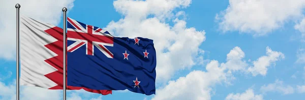 巴林和新西兰国旗在风中飘扬，与白云蓝天相一起。外交概念、国际关系. — 图库照片
