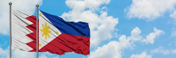 Bahrain and Philippines flag waving in the wind against white cloudy blue sky together. Diplomacy concept, international relations. — Stock Photo, Image