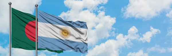 Bandera de Bangladesh y Argentina ondeando en el viento contra el cielo azul nublado blanco juntos. Concepto diplomático, relaciones internacionales . — Foto de Stock
