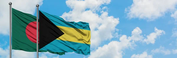 Bangladéš a Bahamská vlajka mávali ve větru proti bíle zatažené modré obloze. Diplomacie, mezinárodní vztahy. — Stock fotografie
