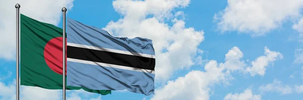Bangladesh e Botswana sventolano insieme la bandiera contro il bianco cielo azzurro nuvoloso. Concetto di diplomazia, relazioni internazionali . — Foto Stock
