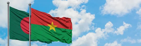 Bandera de Bangladesh y Burkina Faso ondeando en el viento contra el cielo azul nublado blanco juntos. Concepto diplomático, relaciones internacionales . — Foto de Stock
