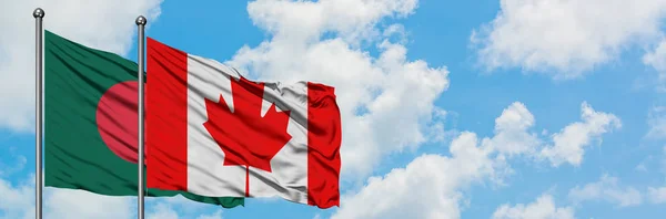 Bandera de Bangladesh y Canadá ondeando en el viento contra el cielo azul nublado blanco juntos. Concepto diplomático, relaciones internacionales . — Foto de Stock