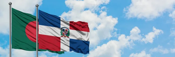 Bandera de Bangladesh y República Dominicana ondeando en el viento contra el cielo azul nublado blanco juntos. Concepto diplomático, relaciones internacionales . — Foto de Stock