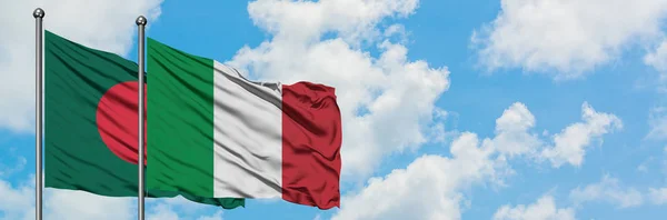 Bandera de Bangladesh e Italia ondeando en el viento contra el cielo azul nublado blanco juntos. Concepto diplomático, relaciones internacionales . — Foto de Stock