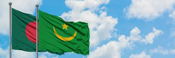 Bandera de Bangladesh y Mauritania ondeando en el viento contra el cielo azul nublado blanco juntos. Concepto diplomático, relaciones internacionales . — Foto de Stock