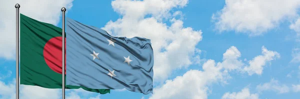 Bandera de Bangladesh y Micronesia ondeando en el viento contra el cielo azul nublado blanco juntos. Concepto diplomático, relaciones internacionales . — Foto de Stock
