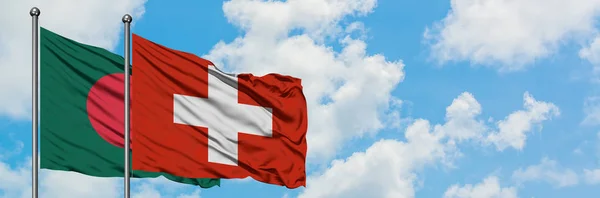 Bangladéš a Švýcarsko mávali větrem ve větru proti bíle zatažené modré obloze. Diplomacie, mezinárodní vztahy. — Stock fotografie
