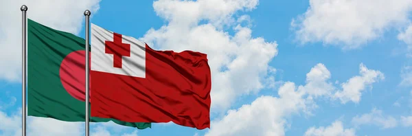 Bandera de Bangladesh y Tonga ondeando en el viento contra el cielo azul nublado blanco juntos. Concepto diplomático, relaciones internacionales . — Foto de Stock