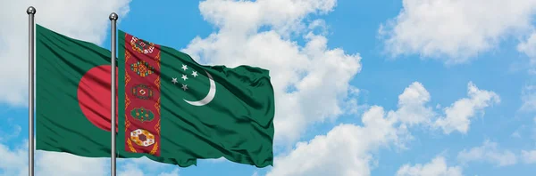 Bangladéši a Turkmenistán vlají ve větru proti bíle zatažené modré obloze. Diplomacie, mezinárodní vztahy. — Stock fotografie