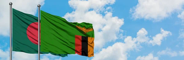 Bandera de Bangladesh y Zambia ondeando en el viento contra el cielo azul nublado blanco juntos. Concepto diplomático, relaciones internacionales . — Foto de Stock