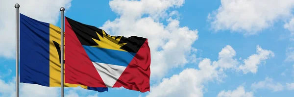 Barbados och Antigua och Barbuda flagga vifta i vinden mot vit grumlig blå himmel tillsammans. Diplomatisk koncept, internationella relationer. — Stockfoto