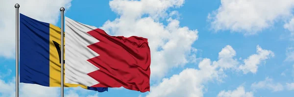 巴巴多斯和巴林国旗在风中飘扬，与白云相间的蓝天相一起。外交概念、国际关系. — 图库照片