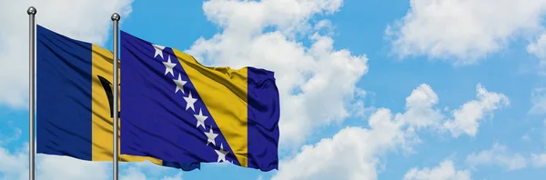 Barbados und Bosnien-Herzegowina schwenken gemeinsam die Flagge im Wind vor dem wolkenverhangenen blauen Himmel. Diplomatie-Konzept, internationale Beziehungen. — Stockfoto