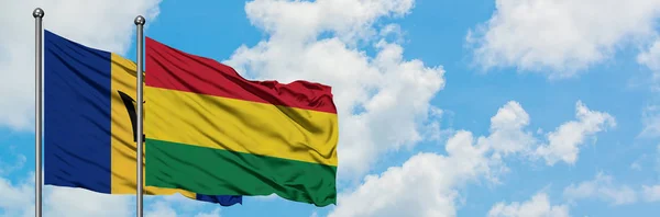 Vlag van Barbados en Bolivia zwaaiende in de wind tegen witte bewolkte blauwe hemel samen. Diplomatie concept, internationale betrekkingen. — Stockfoto