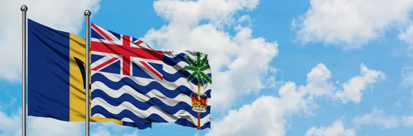 Barbados and British Indian Ocean Territory flag waving in the wind against white cloudy blue sky together. Diplomacy concept, international relations. — Stock Photo, Image