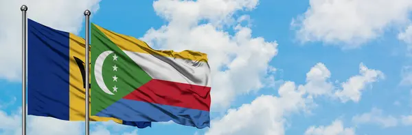 Bandera de Barbados y Comoras ondeando en el viento contra el cielo azul nublado blanco juntos. Concepto diplomático, relaciones internacionales . — Foto de Stock