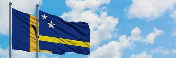 Барбадос і Кюрасао прапор розмахуючи в вітру проти білого хмарного синього неба разом. Концепція дипломатії, міжнародні відносини. — стокове фото