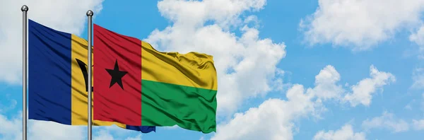 Barbados und Guinea-Bissau schwenken gemeinsam die Flagge im Wind vor dem wolkenverhangenen blauen Himmel. Diplomatie-Konzept, internationale Beziehungen. — Stockfoto