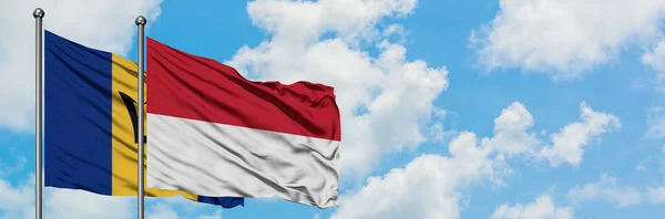 Barbados en Indonesië vlag zwaaiende in de wind tegen witte bewolkte blauwe hemel samen. Diplomatie concept, internationale betrekkingen. — Stockfoto