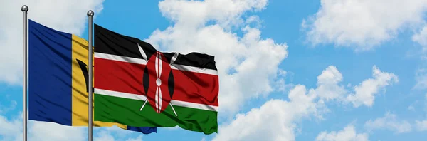Bandera de Barbados y Kenia ondeando en el viento contra el cielo azul nublado blanco juntos. Concepto diplomático, relaciones internacionales . —  Fotos de Stock