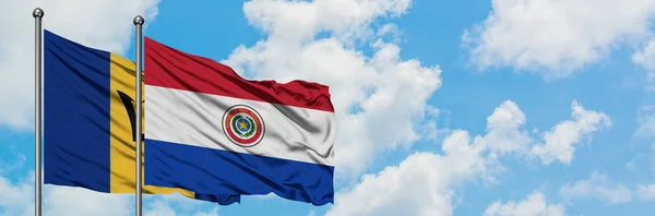 바베이도스와 파라과이 깃발이 하얀 흐린 푸른 하늘을 배경으로 바람에 흔들리고 있습니다. 외교 개념, 국제 관계. — 스톡 사진