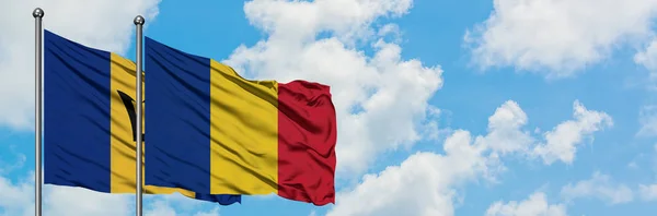 Barbados e Romania bandiera sventolando nel vento contro bianco cielo blu nuvoloso insieme. Concetto di diplomazia, relazioni internazionali . — Foto Stock