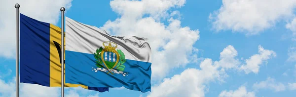 巴巴多斯和圣马力诺国旗在风中飘扬，与白云蓝天相一起。外交概念、国际关系. — 图库照片