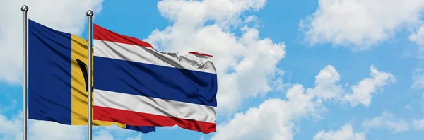 Барбадос и флаг Таиланда, размахивающие ветром против белого облачного голубого неба вместе. Концепция дипломатии, международные отношения . — стоковое фото