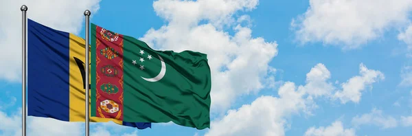 Bandera de Barbados y Turkmenistán ondeando en el viento contra el cielo azul nublado blanco juntos. Concepto diplomático, relaciones internacionales . — Foto de Stock