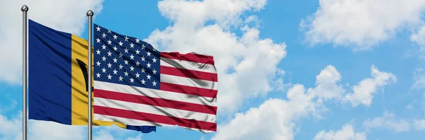 Barbados och Förenta staternas flagga vinka i vinden mot vit grumlig blå himmel tillsammans. Diplomatisk koncept, internationella relationer. — Stockfoto