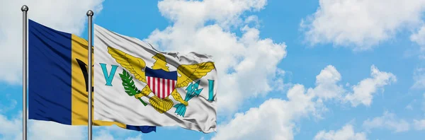 Barbados e Estados Unidos bandeira das Ilhas Virgens acenando no vento contra o céu azul nublado branco juntos. Conceito de diplomacia, relações internacionais . — Fotografia de Stock