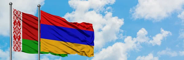 Drapeau de la Biélorussie et de l'Arménie agitant dans le vent contre le ciel bleu nuageux blanc ensemble. Concept de diplomatie, relations internationales . — Photo