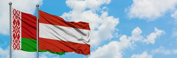 Fehéroroszország és Ausztria zászló integetett a szél ellen, fehér felhős kék eget együtt. Diplomáciai koncepció, nemzetközi kapcsolatok. — Stock Fotó