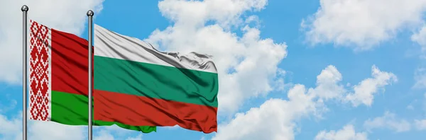Bandera de Bielorrusia y Bulgaria ondeando en el viento contra el cielo azul nublado blanco juntos. Concepto diplomático, relaciones internacionales . — Foto de Stock