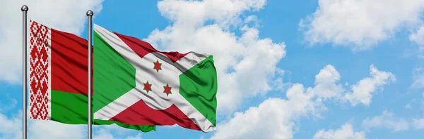 Beyaz Rusya ve Burundi bayrağı birlikte beyaz bulutlu mavi gökyüzüne karşı rüzgarda sallayarak. Diplomasi kavramı, uluslararası ilişkiler. — Stok fotoğraf
