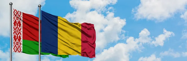 Drapeau du Bélarus et du Tchad agitant dans le vent contre le ciel bleu nuageux blanc ensemble. Concept de diplomatie, relations internationales . — Photo