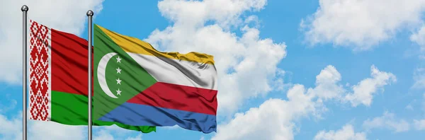 Bandera de Bielorrusia y Comoras ondeando en el viento contra el cielo azul nublado blanco juntos. Concepto diplomático, relaciones internacionales . — Foto de Stock