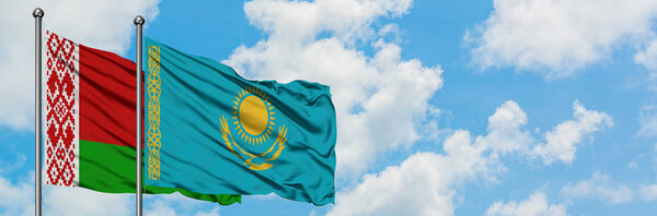 Belarus and Kazakhstan flag waving in the wind against white cloudy blue sky together. Diplomacy concept, international relations.