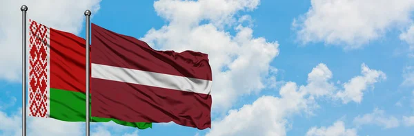 Belarus and Latvia flag waving in the wind against white cloudy blue sky together. Diplomacy concept, international relations. — Stock Photo, Image