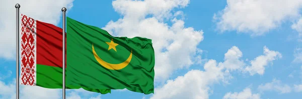 Bandera de Bielorrusia y Mauritania ondeando en el viento contra el cielo azul nublado blanco juntos. Concepto diplomático, relaciones internacionales . — Foto de Stock
