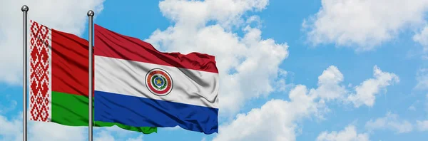 Bandera de Bielorrusia y Paraguay ondeando en el viento contra el cielo azul nublado blanco juntos. Concepto diplomático, relaciones internacionales . — Foto de Stock