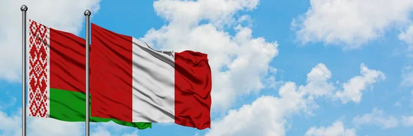 Belarus and Peru flag waving in the wind against white cloudy blue sky together. Diplomacy concept, international relations. — Stock Photo, Image