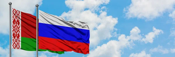 Bielorussia e Russia bandiera sventolando nel vento contro bianco cielo blu nuvoloso insieme. Concetto di diplomazia, relazioni internazionali . — Foto Stock